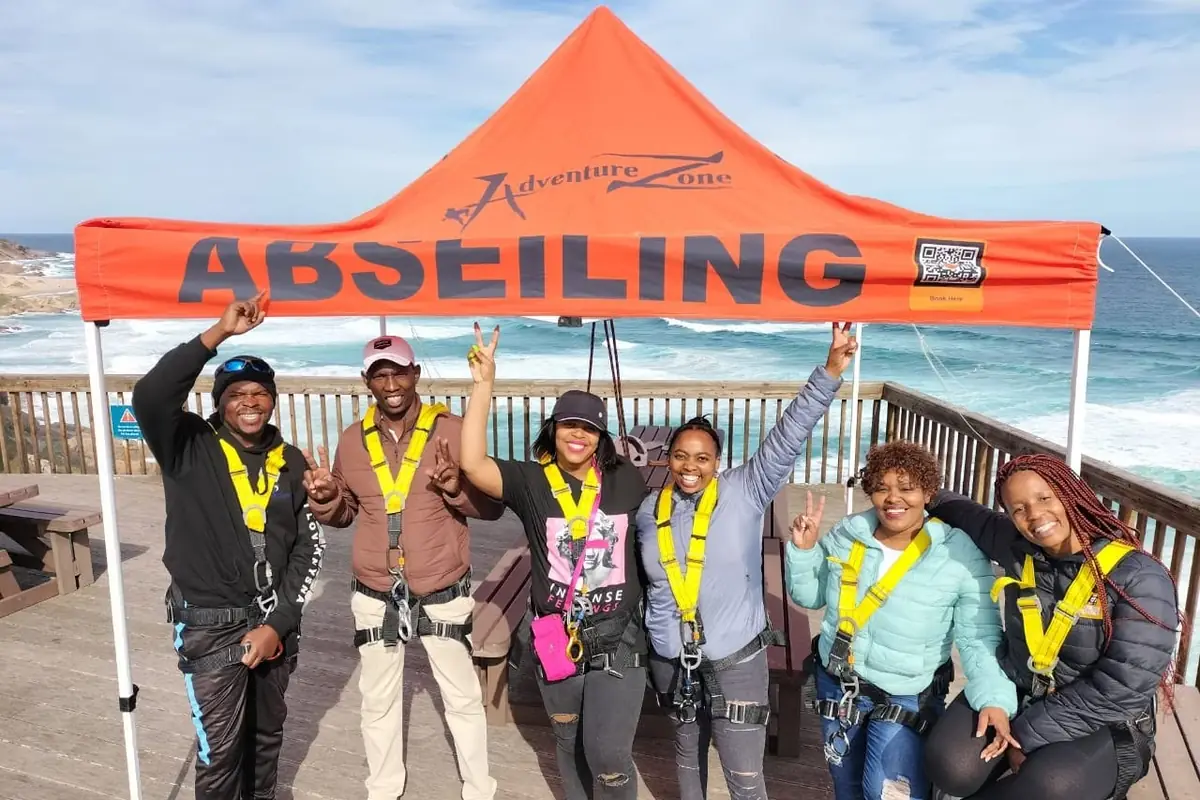 A group at the abseiling site above the sea