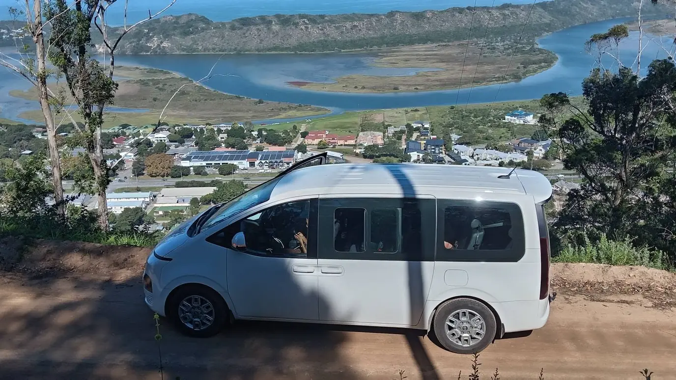 A Jonas Gidwa Tours minibus at a Garden Route viewpoint above the lagoon