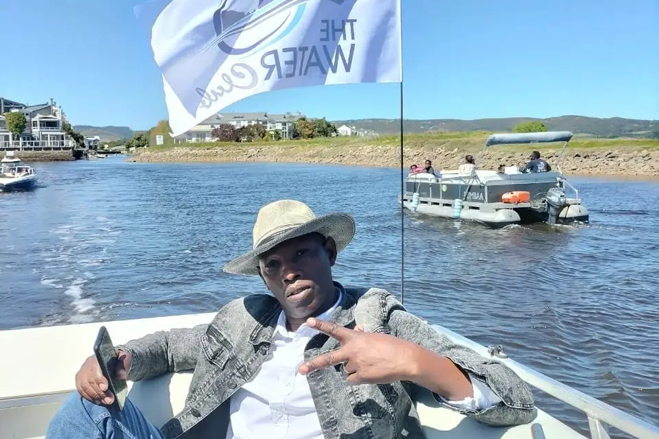 Jonas on the Knysna lagoon with boats moored behind him