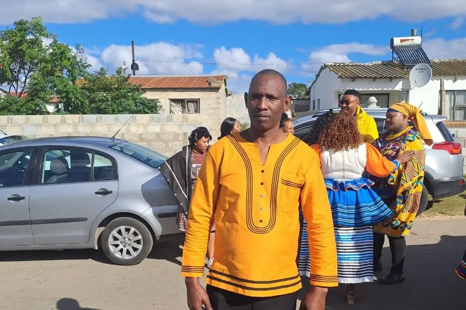Jonas on a township street in Knysna with residents in traditional dress